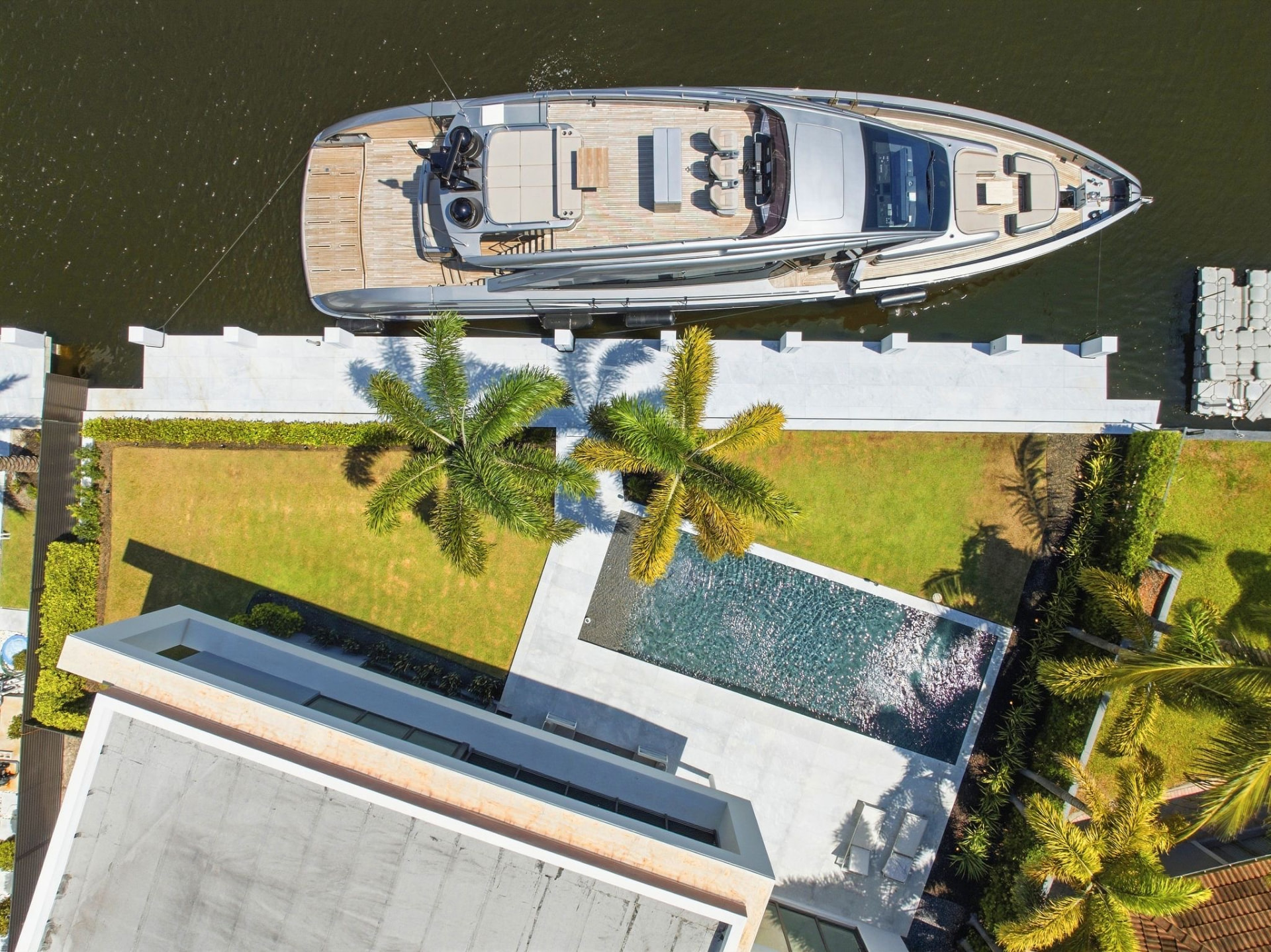 Overhead view of the yacht, private dock, pool, and waterfront grounds